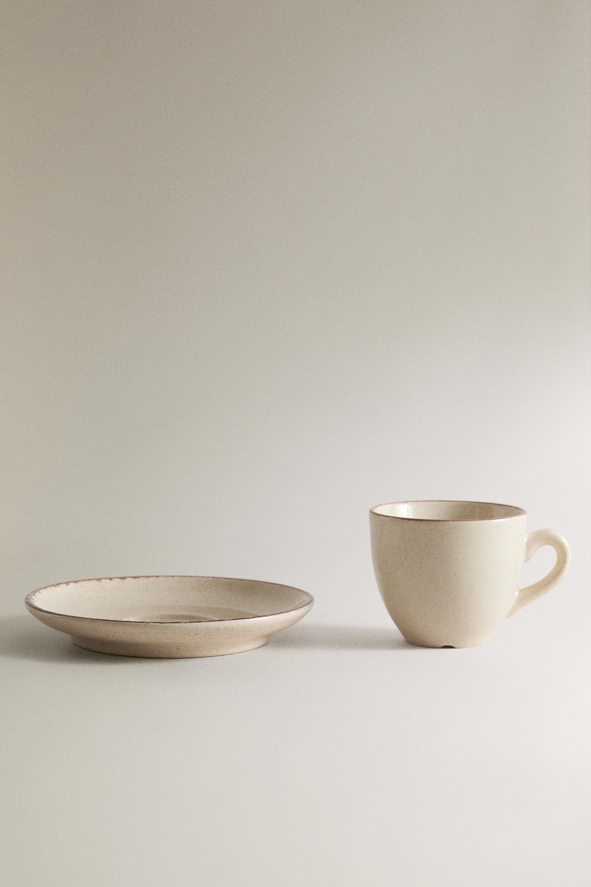 STONEWARE COFFEE CUP AND SAUCER WITH DISTRESSED RIM
